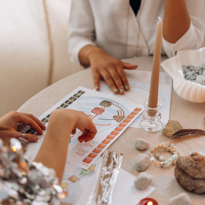 A woman smiling peacefully while sitting in a lotus yoga pose.