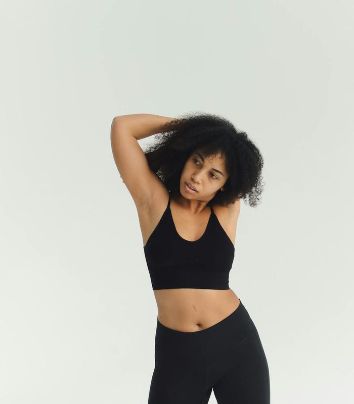 Woman in a calm yoga pose in a bright, minimalist studio.